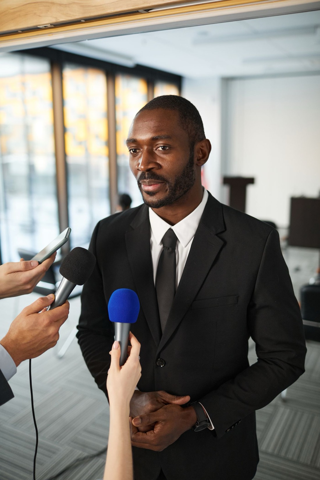 A leader fielding journalists' microphones with composure